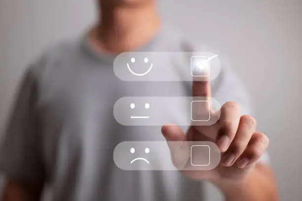 Photo of Business people touching the virtual screen on the joyful Smile face icon to give happiness in service is a customer service and satisfaction concept. Very impressed with the rating.