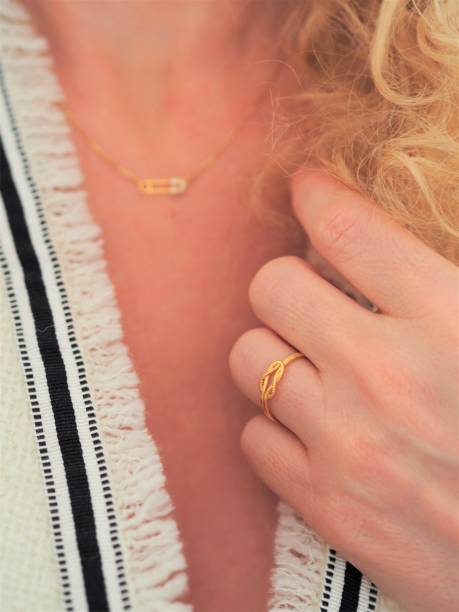 istock Safety pin necklace and lace ring on a white tweed jacket 1348567683