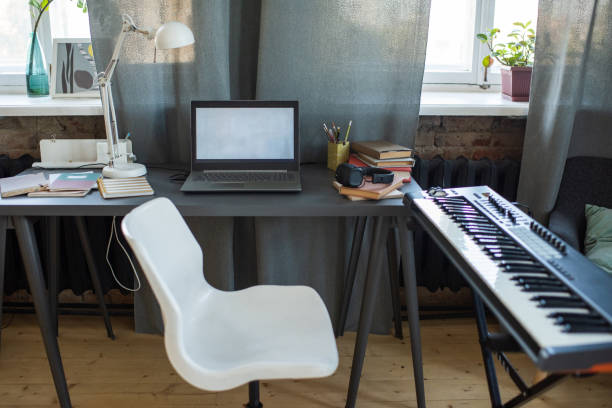 istock White chair standing between table with laptop and piano keyboard 1348571595