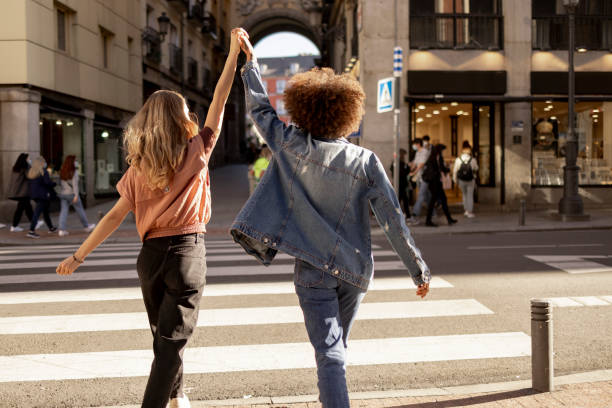 visão traseira de um jovem casal lésbico feliz se divertindo juntos na cidade - direitos da mulher - fotografias e filmes do acervo