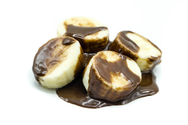 istock Bananas with chocolate sauce isolated on white background 1348572337