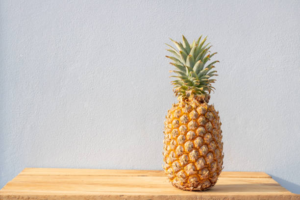 istock Ripe pineapple isolated on wooden table 1348572666