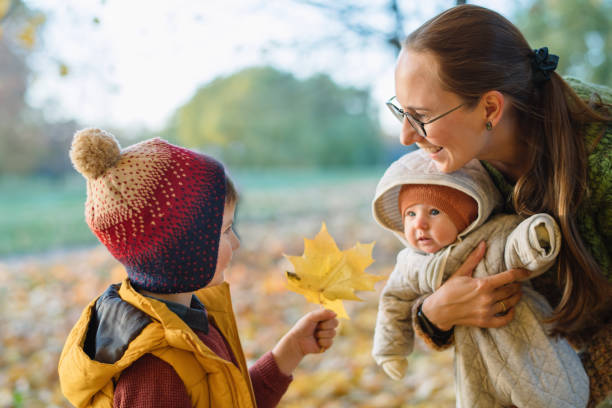 familie genießt sonnige herbsttage in einem park - baby toddler child flower stock-fotos und bilder