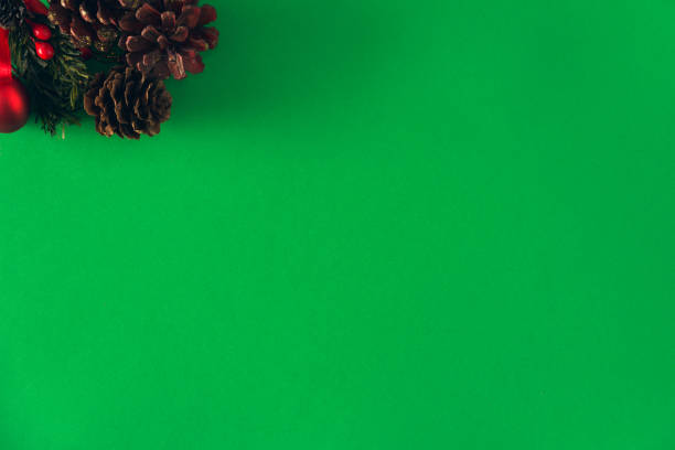 istock Christmas pine cones with red ribbon on green background. Copy space. Selective focus. 1348575862