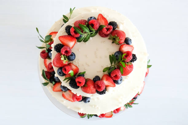istock White wedding cake, with slices strawberries, raspberries, blackberry on a white background. 1348576105