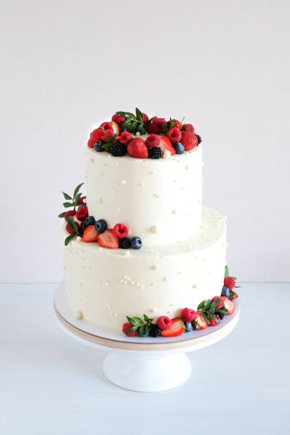 istock White wedding cake, with slices strawberries, raspberries, blackberry on a white background. 1348576107