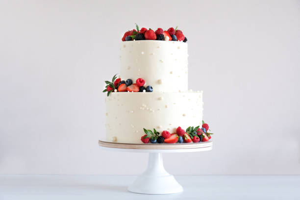 istock White wedding cake, with slices strawberries, raspberries, blackberry on a white background. 1348576113