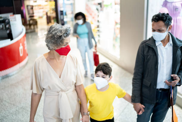 istock Family walking at the mall - using a face mask 1348576992