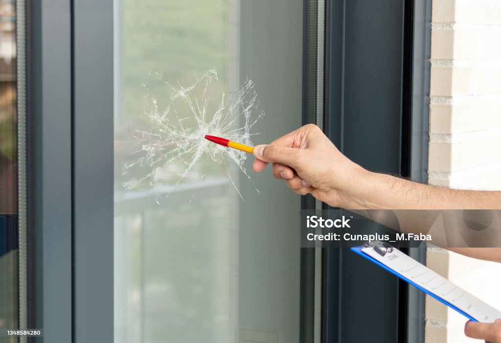 man checking to repair glass in a house Close-up of a man's hand checking to repair glass in a house for a window accident Shattered Glass Stock Photo