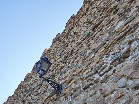 Close-up of the city wall of  the medieval village Buitrago del Lozoya seen from below, with an iron lantern. Province of Madrid, Spain, Europe