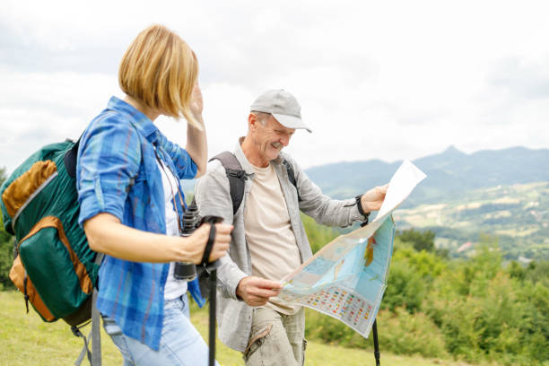 istock Father and daughter looking at a map during a hike 1348608425