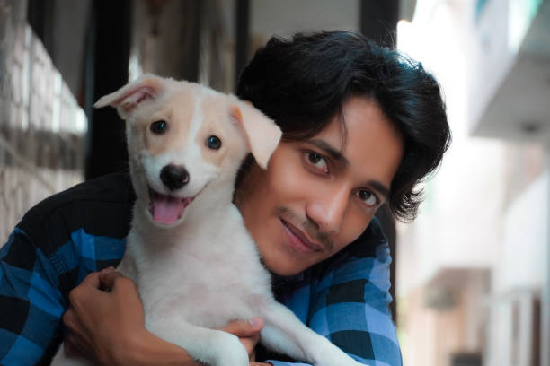 istock Young man setting with a cute puppy 1348615590