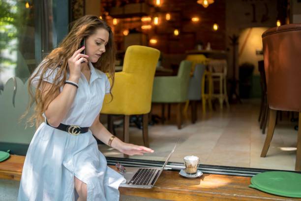 istock Businesswoman using laptop while enjoying work at cafe table with cup of coffee 1348619581