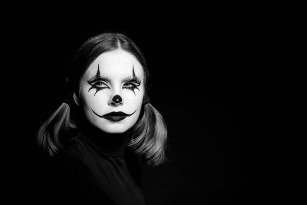 Emotional Portrait of a scary clown woman on a dark background. stock photo