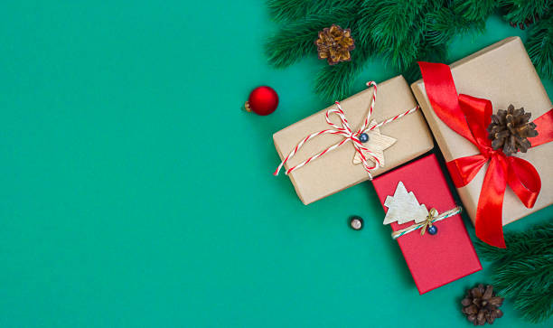 istock gift boxes and fir branches on a green background. 1348652918