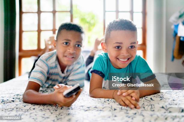 Smiling Little Brothers Watching Tv In Their Bedroom At Home Stock Photo - Download Image Now