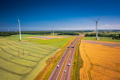 Aerial view of golden field and wind turbines near highway. Agriculture in Poland.