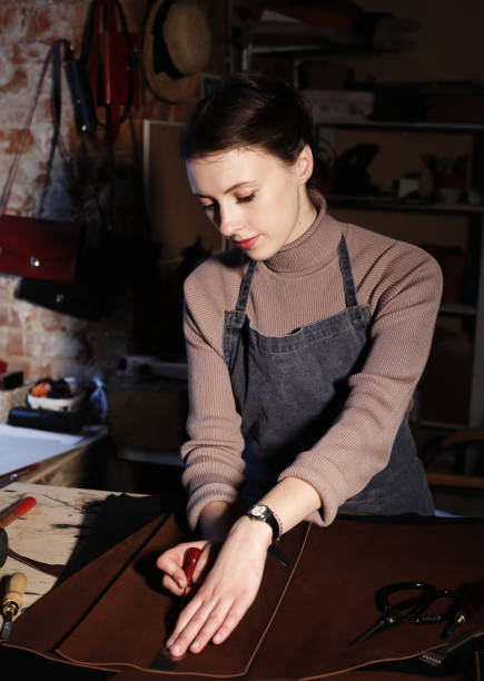 istock young brunette woman works in a bag making studio, cuts out details 1348665578