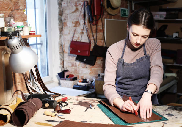 istock young brunette woman works in a bag making studio, cuts out details 1348665664
