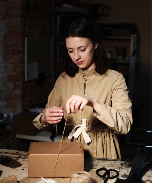 istock young woman folds packing box in sewing workshop 1348665955