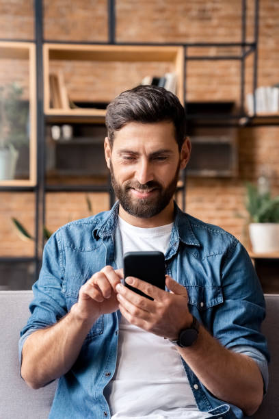 istock Smiling caucasian employee using smartphone enjoy work break at home office 1348667923