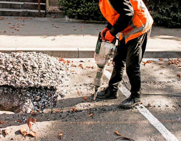 i lavoratori rimuovono uno strato di vecchio asfalto con un martello pneumatico in un giorno d'autunno. - jackhammer road construction construction worker road foto e immagini stock