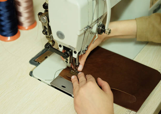 istock Closeup on young woman sewing leather handbag 1348668201