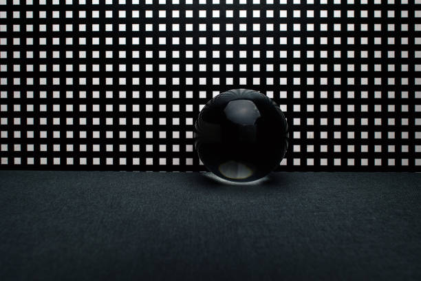 istock Dark glass toy sphere over square holed black lattice background 1348671653