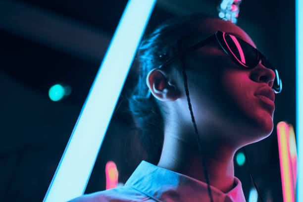 Teenage asian girl in sun glasses in neon light stock photo