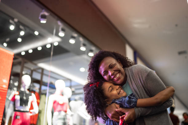 istock Mother and daughter hugging each other at the mall 1348674290