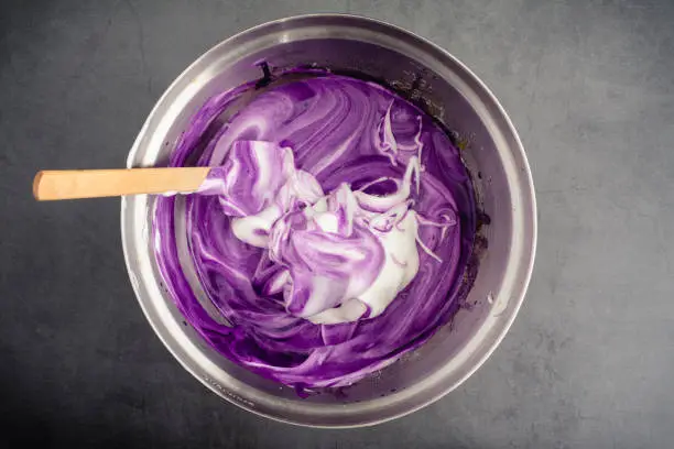 Using a spatula to mix up cake batter made with purple sweet potatoes