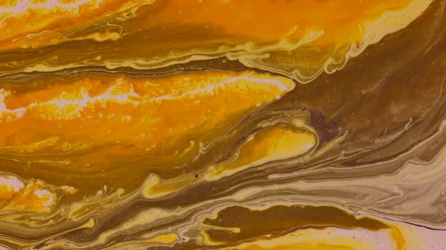 Fluid abstract acrylic and ink texture with colorful waves. Liquid paint and ink mixing. Red, yellow, green and metallic color.