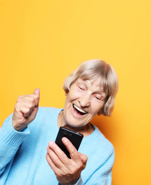 istock old woman wearing blue sweater talking on cell phone 1348677595