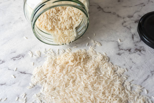 Fallen glass jar with basmati rice spilled in foreground
