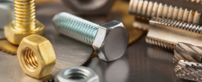 nuts, bolts, screws, washers, bearings on a metal steel background.