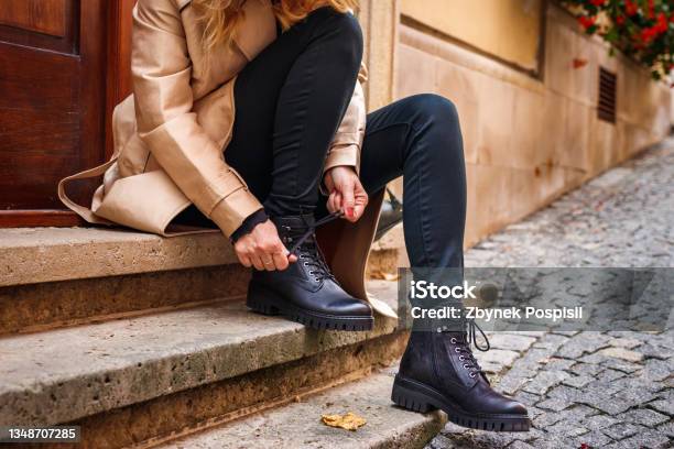 Stylish Woman Tying Shoelace Of Black Ankle Boot Stock Photo - Download Image Now - Boot, Shoe, One Woman Only