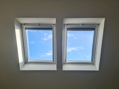 Skylights in loft conversion showing blue sky with a few small clouds