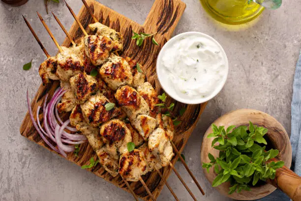 Greek chicken souvlaki with tzatziki sauce and fresh vegetables, grilled kebabs