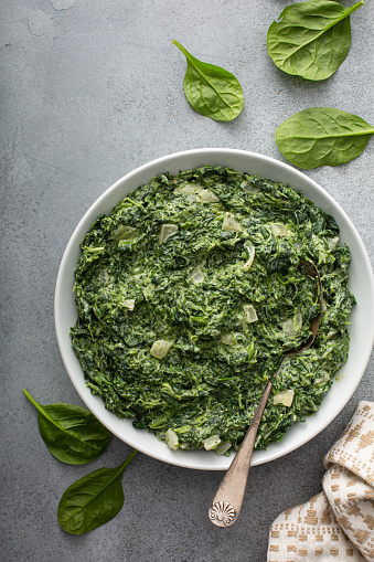 Homemade creamed spinach with garlic in a bowl overhead view