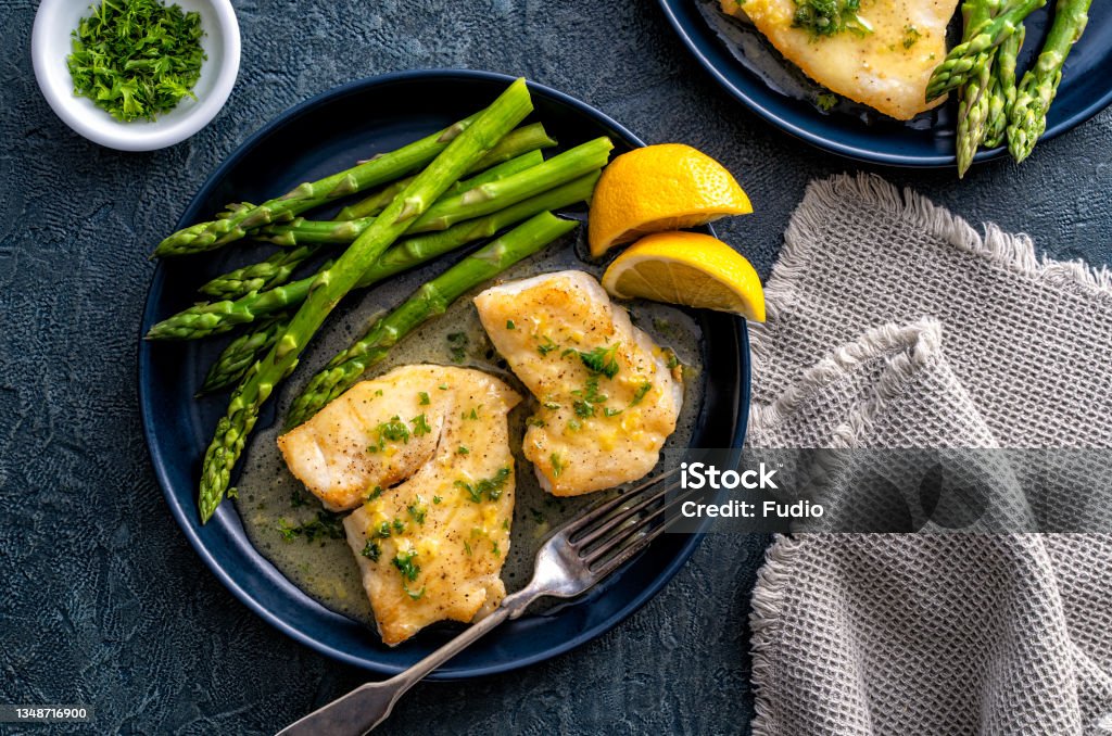 Pan Seared Halibut Delicious pan seared halibut with lemon butter sauce and asparagus. Fish Stock Photo