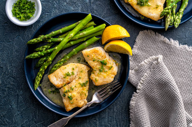 Pan Seared Halibut Delicious pan seared halibut with lemon butter sauce and asparagus. haddock stock pictures, royalty-free photos & images