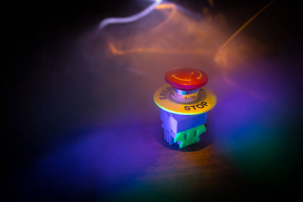 istock Emergency stop button, Disaster protection. Industrial concept. Red button on table in dark low key background. 1348716919