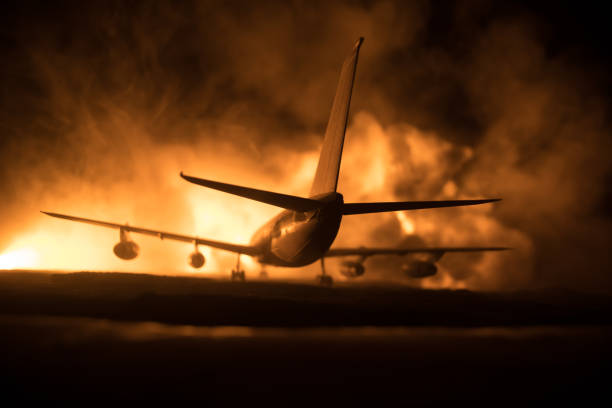 istock Air Crash. Burning falling plane. The plane crashed to the ground. Decorated with toy at dark fire background. Air accident concept. 1348716940