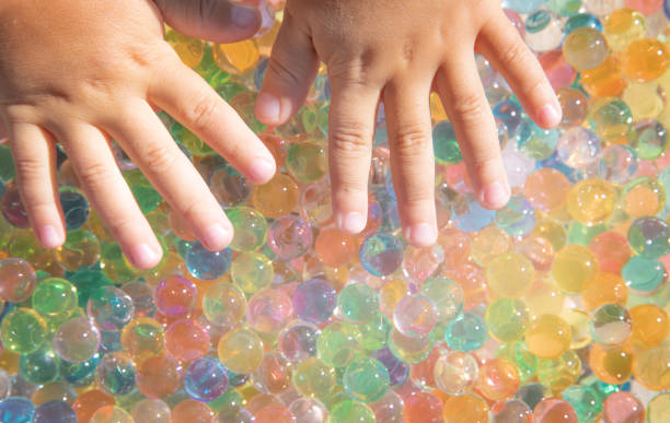 istock Colored balls of hydrogel touch children's hands. Sensory sensations 1348718272