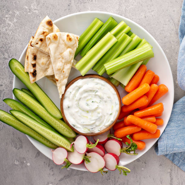 Large snack board with tzatziki dip or sauce and fresh vegetables stock photo