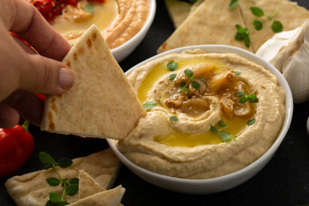 hummus de ajo asado cubierto con aceite de oliva - avocado lemon snack cracker fotografías e imágenes de stock