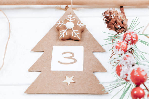 istock One handicraft Christmas tree with number 3, biscuits and a spruce branch hang on a jute thread and on a hanger on a white 1348719887