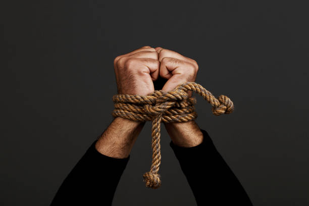 Hands  tied with rope Hands  tied with rope, on dark background tying stock pictures, royalty-free photos & images