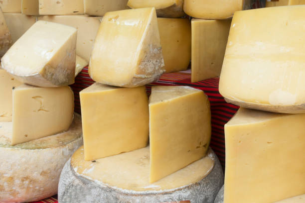 istock Cheese wheels on wooden table 1348745946