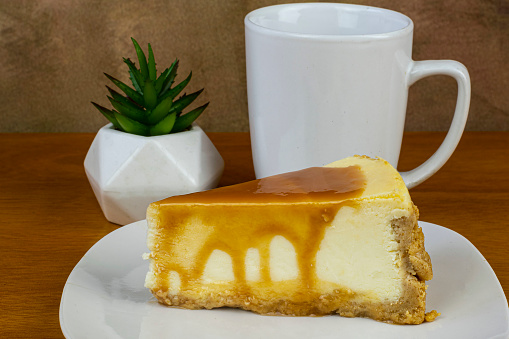 carmel top cheese cake served with a cup of coffee